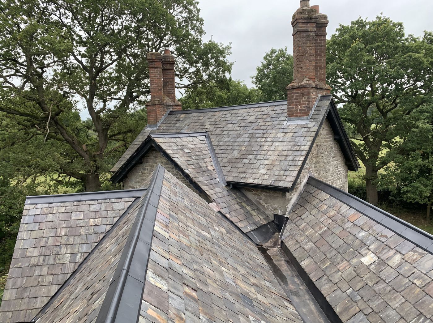 A roof with intersecting gables and open metal valleys running between the planes